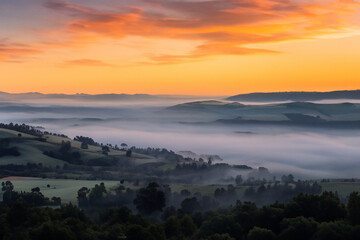 Fototapeta premium A valley shrouded in mist, glowing with the first light of sunrise.