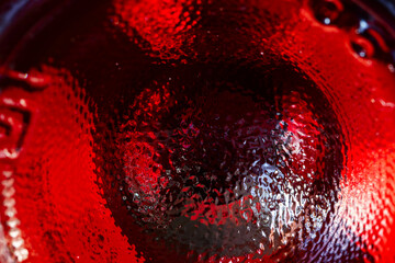 Closeup of glass bottle bottom with red liquid