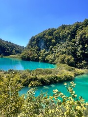 Plitvice Lakes in Croatia, a breathtaking natural wonder, transforms into a lush paradise during summer. Vibrant green forests, cascading waterfalls, and crystal-clear lakes create a serene, enchantin