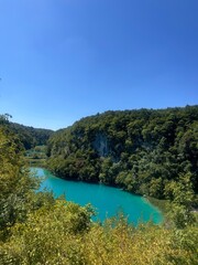 Plitvice Lakes in Croatia, a breathtaking natural wonder, transforms into a lush paradise during summer. Vibrant green forests, cascading waterfalls, and crystal-clear lakes create a serene, enchantin