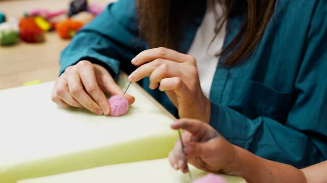 Participants create colorful felt ornaments through needle felting activities