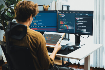 Working IT developer reading coding on document paper software with screens pc at modern office on...