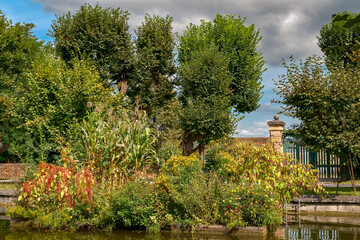Künstliche Insel mit Blumenschmuck im barocken Wasserbecken an der östlichen Mauer des Stiftparks von Melk