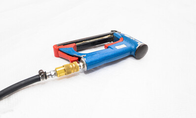 industrial air stapler, stapler for making furniture, beds, wooden parts. Closed angle, close-up, isolated white background.