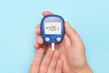 Person checking blood sugar level with glucometer