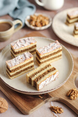 Traditional walnut pie on a plate. Cup of coffee and blue napkin in the background.