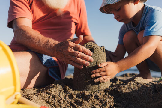 Grandfather and Grandson Building Sandcastles Together