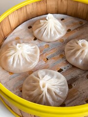 Steamed xiao long bao in bamboo steaming bowl. Chinese steamed bun. Dim sum. Chinese food