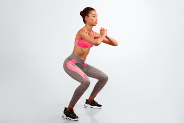 Fitness Workout. Afro Girl Doing Deep Squat Exercise Over Pink Background. Studio Shot