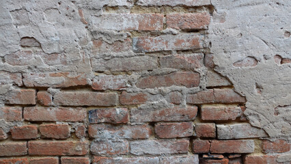 Weathered Brick Wall With Peeling Plaster in Urban Setting
