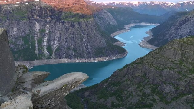 Trollgunga, Trolls Tongue at sunrise, the Famous cliff above the Abyss. Blue Lake underneath, Troll, Trolltunga, Norway