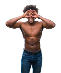 Fototapeta premium Afro american shirtless man showing nude body over isolated background doing ok gesture like binoculars sticking tongue out, eyes looking through fingers. Crazy expression.