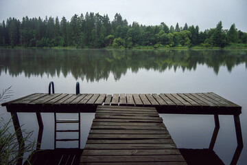 Naklejka premium A wooden pier going into the water.A bridge made of planks for those who like to dive into the water.Own boat pier.