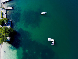 A clear azure lagoon with beaches and several private boats at anchor