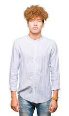 Young handsome business man with afro hair wearing elegant shirt Relaxed with serious expression on face. Simple and natural looking at the camera.