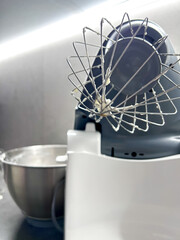 Mixer in the kitchen at home. Equipment for making cream. Professional mixer is on the table. Mixer whips cream. Pastry tools. Making a cake
