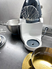 Mixer in the kitchen at home. Equipment for making cream. Professional mixer is on the table. Mixer whips cream. Pastry tools. Making a cake