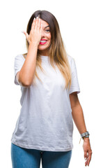 Fototapeta premium Young beautiful woman casual white t-shirt over isolated background covering one eye with hand with confident smile on face and surprise emotion.