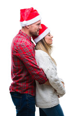 Young couple in love wearing christmas hat over isolated background looking to side, relax profile pose with natural face with confident smile.