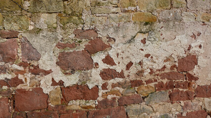 Textured Old Stone Wall With Exposed Bricks and Peeling Plaster in Daylight
