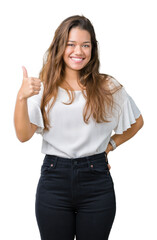 Young beautiful brunette business woman over isolated background doing happy thumbs up gesture with hand. Approving expression looking at the camera showing success.