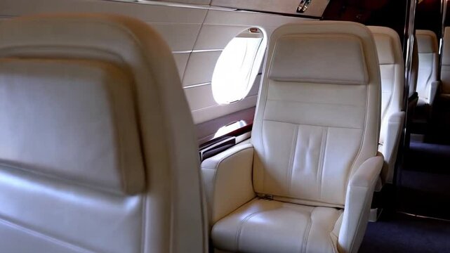Private jet cabin interior with sleek white leather seats and a minimalist design.