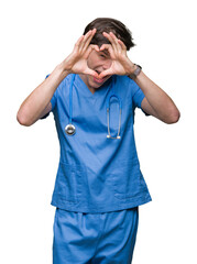 Young doctor wearing medical uniform over isolated background Doing heart shape with hand and fingers smiling looking through sign