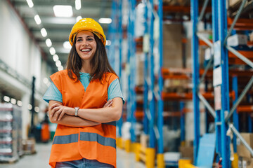 Female warehouse worker smiling with crossed arms