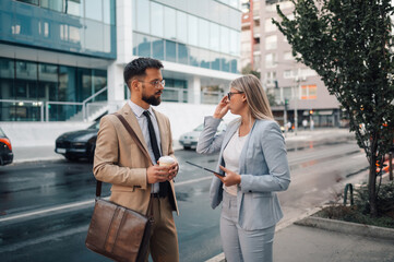 Business people having conversation about work on city street