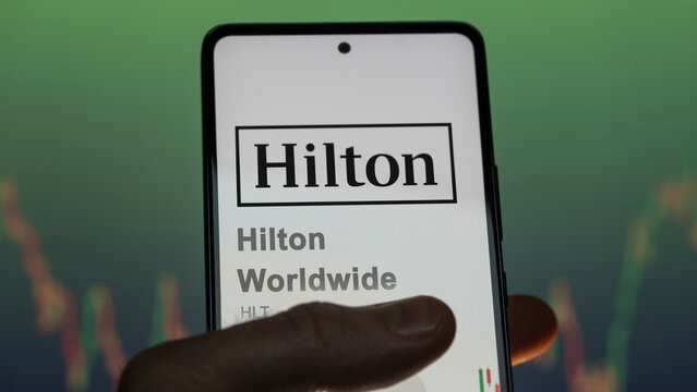 April 09th 2024 , Tysons Corner, Virginia. Close up on logo of Hilton Worldwide on the screen of an exchange. Hilton Worldwide price stocks, $HLT on a device.