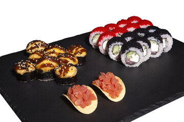 Sushi set and nachos with salmon on a slate plate isolated on black background. 3 types of rolls in one set.