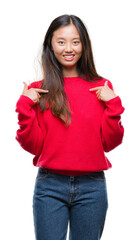 Young asian woman wearing winter sweater over isolated background looking confident with smile on face, pointing oneself with fingers proud and happy.