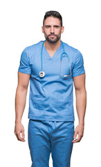 Fototapeta premium Handsome young doctor surgeon man over isolated background Relaxed with serious expression on face. Simple and natural looking at the camera.