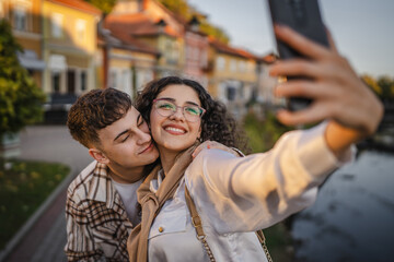 Obraz premium Young happy couple take a self portrait with river in the background