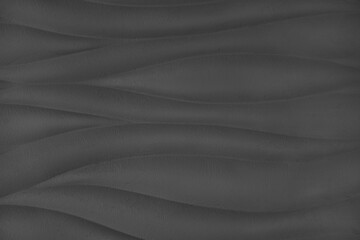 Plaster wall with volumetric relief surface wavy form pattern, black gypsum texture panel.