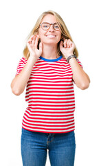 Beautiful young woman wearing glasses over isolated background Smiling pulling ears with fingers, funny gesture. Audition problem