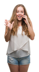 Young blonde woman using smartphone very happy and excited, winner expression celebrating victory screaming with big smile and raised hands