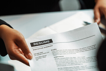 Close up view of employee candidate hands CV resume document to the interviewer HR human resources department manager at the interview room. Job application, recruit and labor hiring concept. uds