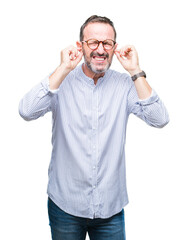 Naklejka premium Middle age hoary senior man wearing glasses over isolated background covering ears with fingers with annoyed expression for the noise of loud music. Deaf concept.