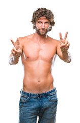 Fototapeta premium Handsome hispanic model man sexy and shirtless over isolated background smiling looking to the camera showing fingers doing victory sign. Number two.