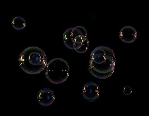 Floating Soap Bubbles with Rainbow Reflections on Black Background