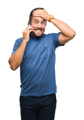 Fototapeta premium Young handsome man talking on smartphone over isolated background stressed with hand on head, shocked with shame and surprise face, angry and frustrated. Fear and upset for mistake.
