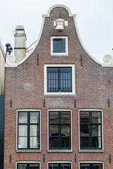 Colorful old buildings with gable rooftops and hooks along Herengracht canal. In XVII century richest merchants, most influential regents and mayors lived on this canal. Amsterdam, the Netherlands.