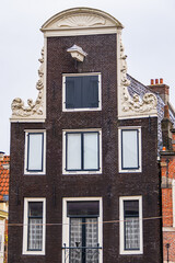 Colorful old buildings with gable rooftops and hooks along Herengracht canal. In XVII century...