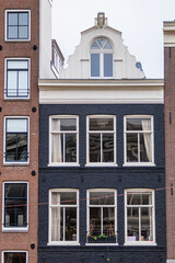 Colorful old buildings with gable rooftops and hooks along Herengracht canal. In XVII century richest merchants, most influential regents and mayors lived on this canal. Amsterdam, the Netherlands.