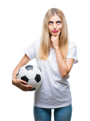 Young beautiful blonde woman holding soccer ball over isolated background serious face thinking about question, very confused idea