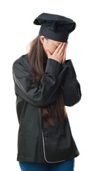 Fototapeta premium Young Chinese woman over isolated background wearing chef uniform with sad expression covering face with hands while crying. Depression concept.