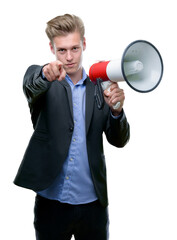 Young handsome blond man holding a megaphone pointing with finger to the camera and to you, hand sign, positive and confident gesture from the front