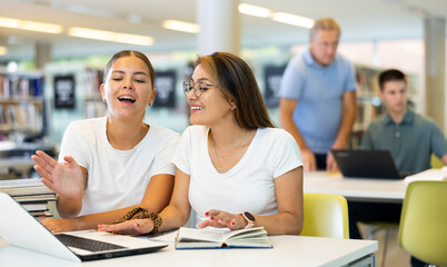 Obraz premium Young female students studying together compared to a noisy male in the background