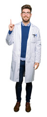 Young handsome scientist man wearing glasses pointing finger up with successful idea. Exited and...